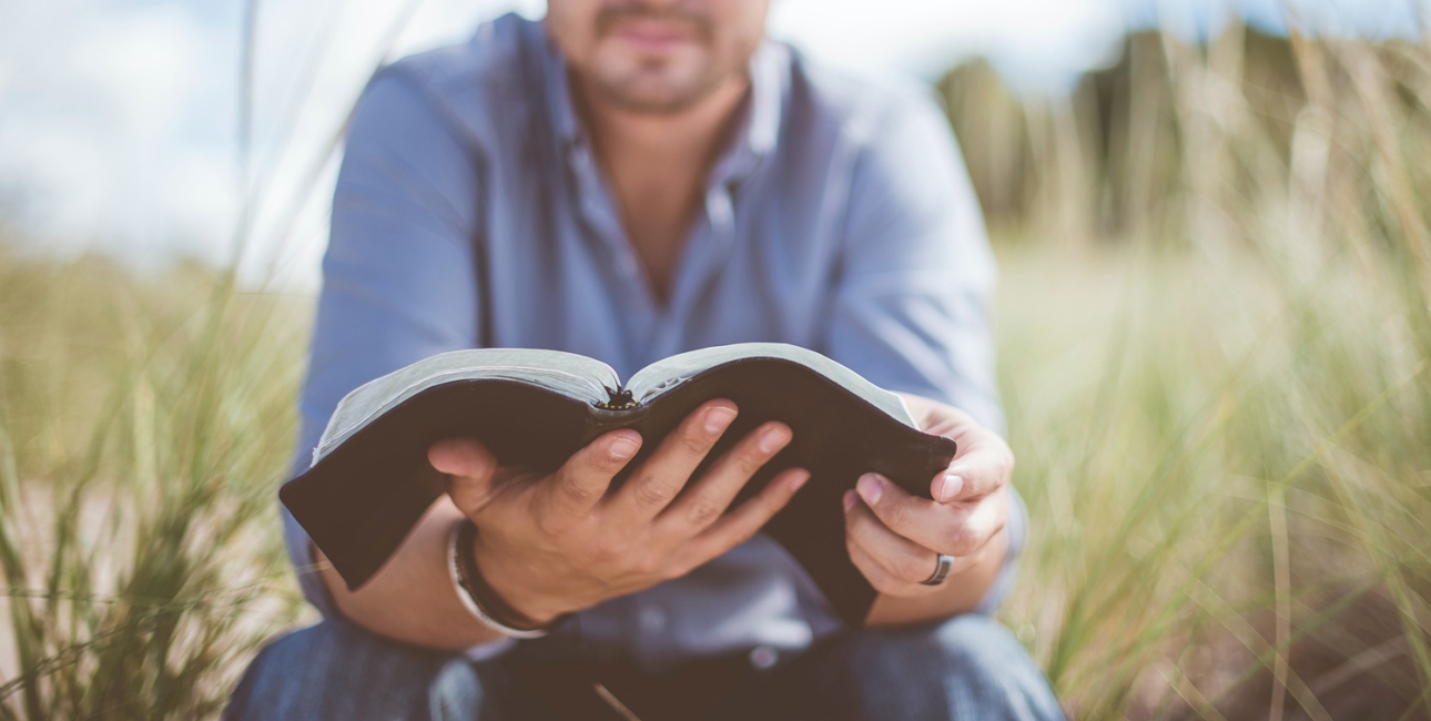 Mand læser i bibel. Foto: Unsplash.