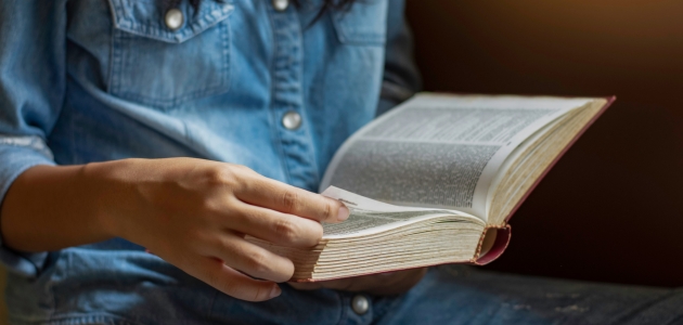 En kvinde læser i Bibelen. Foto: NIKCOA / Shutterstock.com.