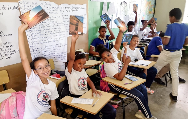 Børn løfter bibler i vejret